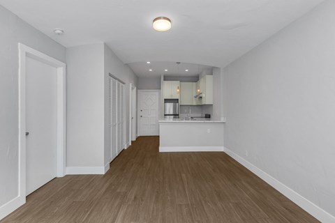 A kitchen area with a refrigerator, sink, and cabinets.