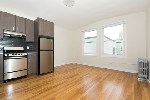 A kitchen with wooden floors and stainless steel appliances.