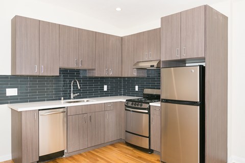 A kitchen with wooden cabinets and a black fridge.