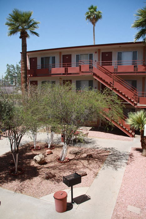 a courtyard with palm trees in front of a building