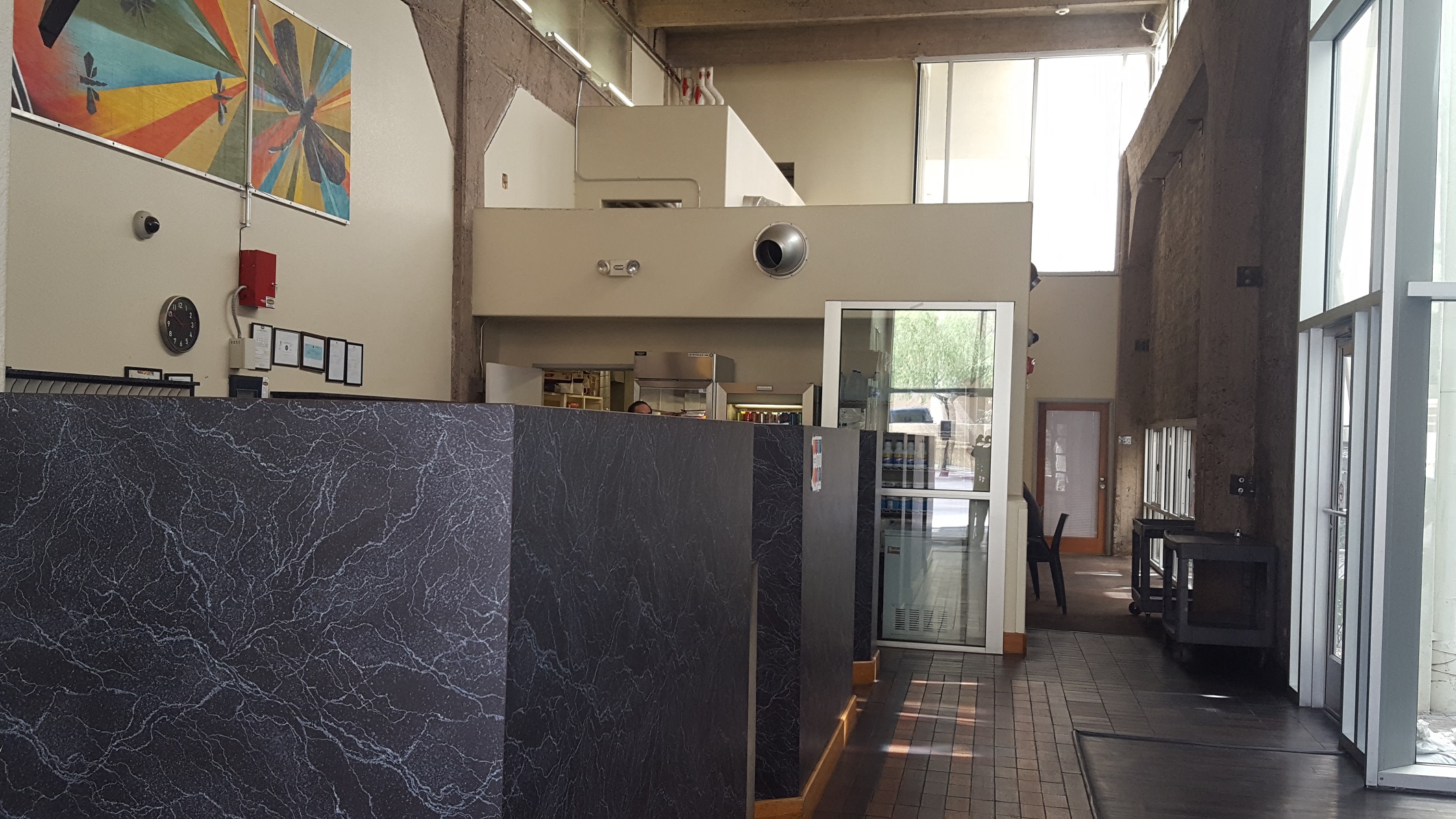 a view into the kitchen from the lobby of a building with a black marble counter