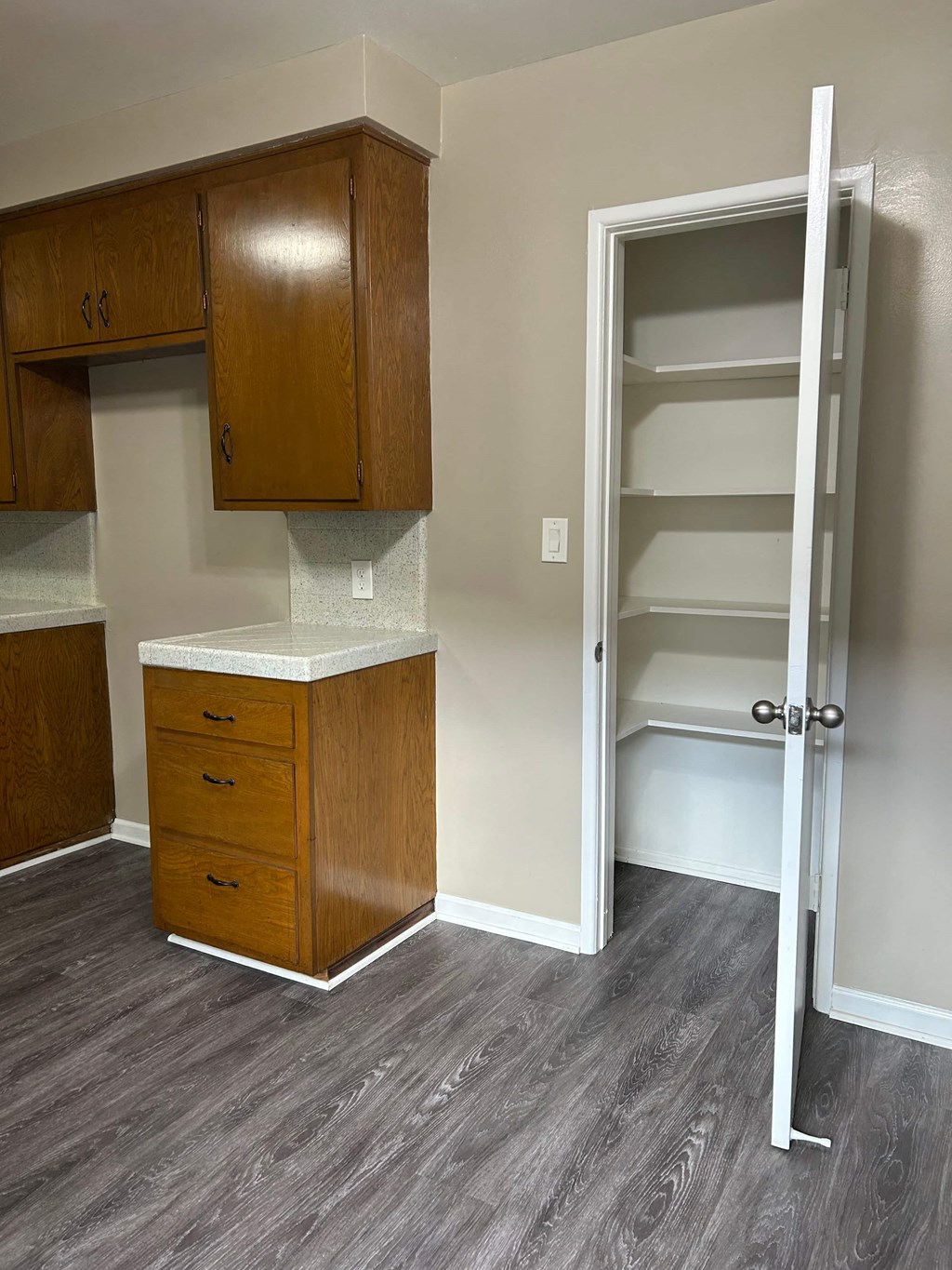A kitchen with a white door open to a pantry.