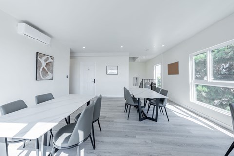 a large white conference room with a long table and chairs