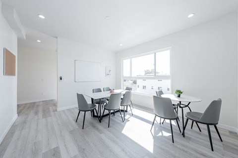 a dining room with a table and chairs and a large window