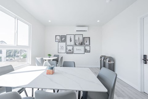 a white meeting room with a white table and chairs
