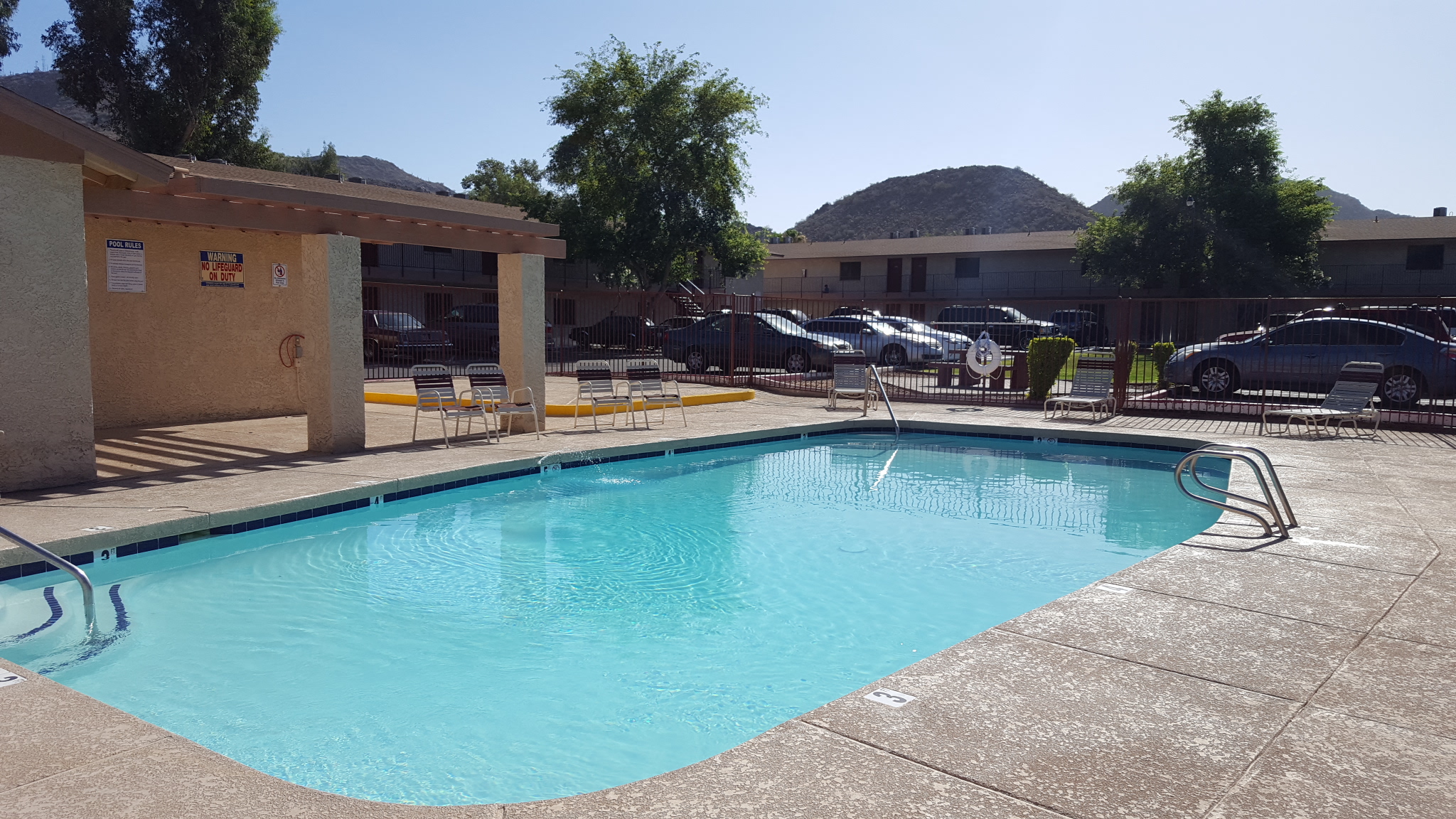 a swimming pool at a hotel with a mountain in the background