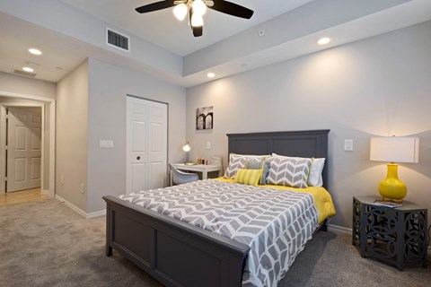 A bedroom with a large bed and a ceiling fan.