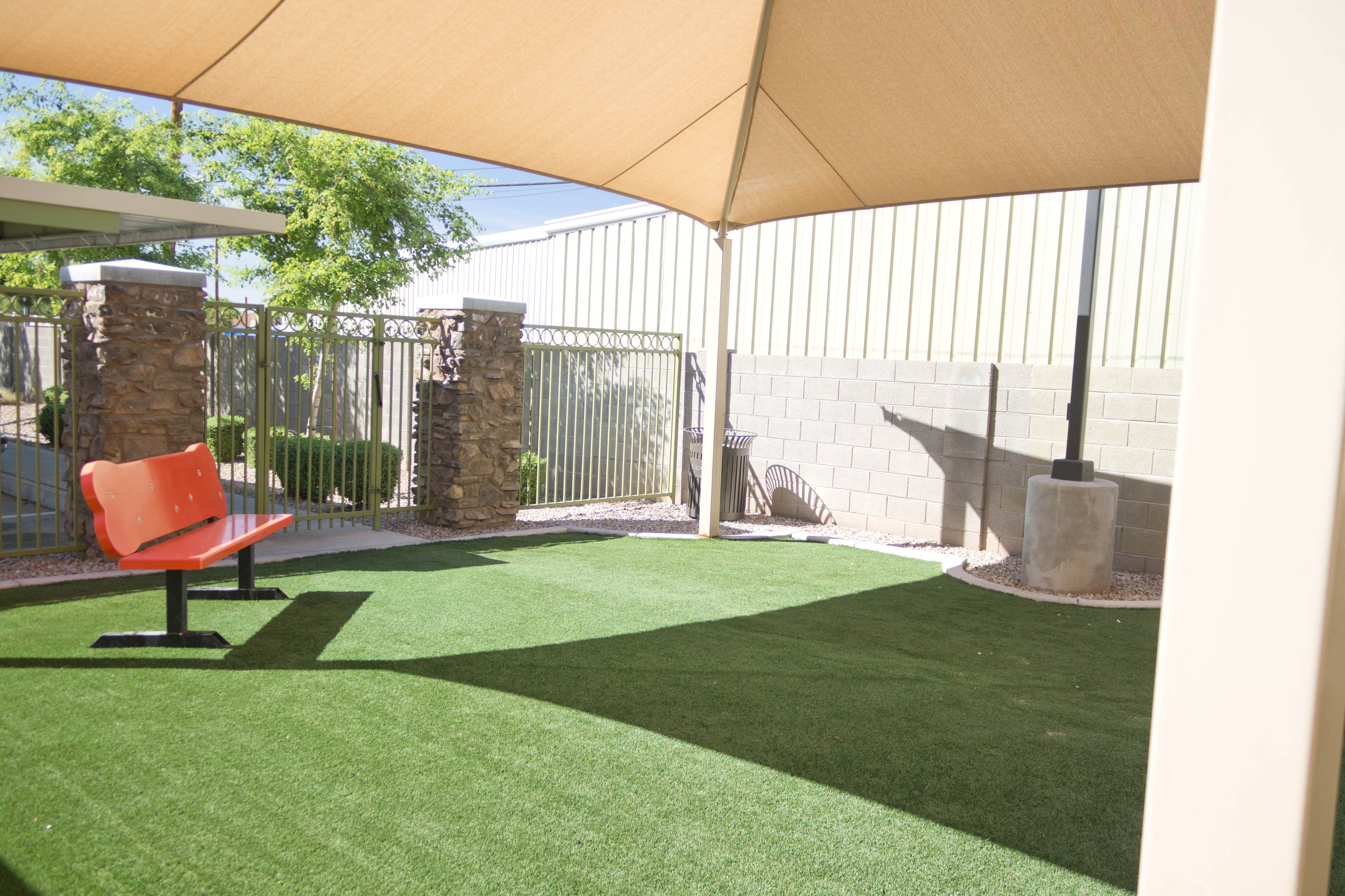 a patio with a red chair and artificial grass