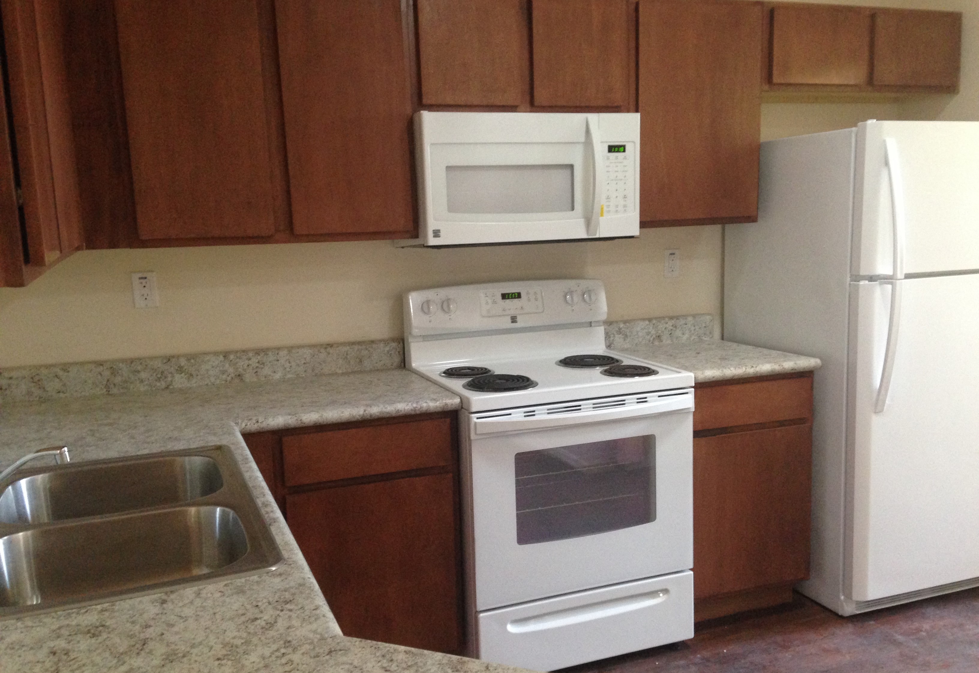 a kitchen with white appliances and wooden cabinets