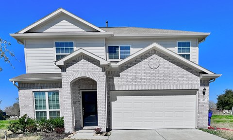 a white house with a garage door in front of it