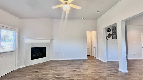 a living room with a fireplace and a ceiling fan