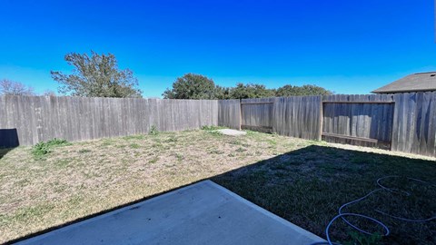 a backyard with a fence and a yard with grass