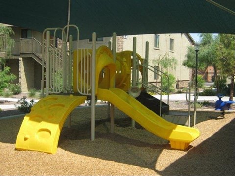 a childrens playground with a yellow slide