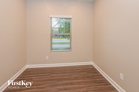 a empty room with wood floors and a window