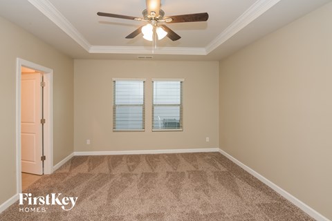 a empty room with a ceiling fan and two windows