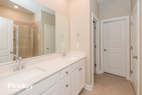 a white bathroom with two sinks and a large mirror