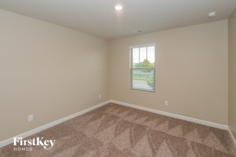 a empty room with carpet and a window