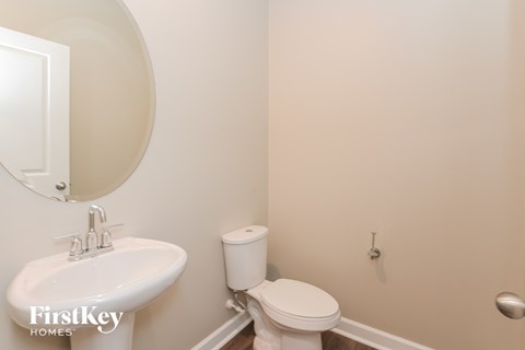 a bathroom with a toilet and a sink and a mirror