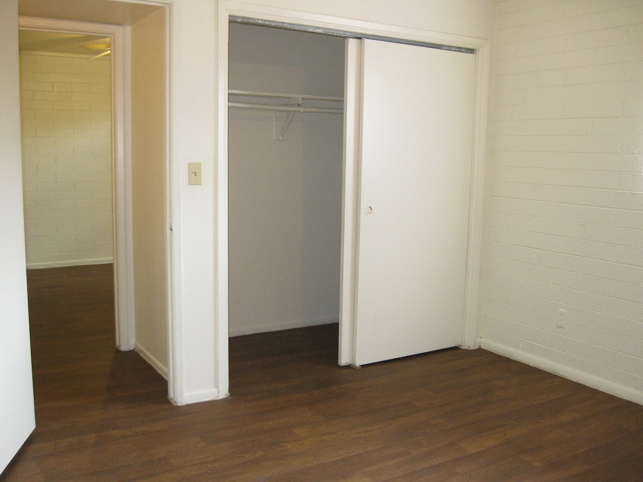a bedroom with a closet and a hard wood floor