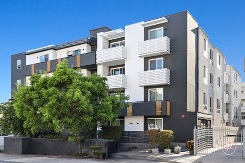A modern apartment building with a mix of black, white, and beige colors.