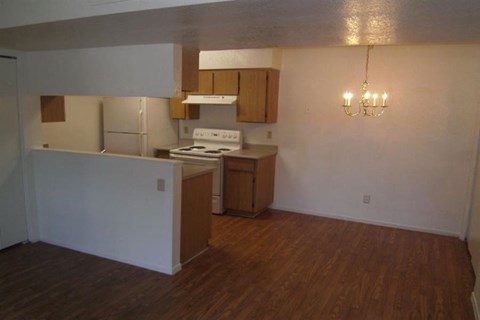 an empty kitchen with a stove and a refrigerator