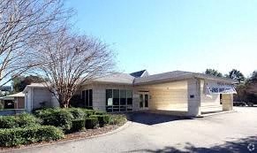 A modern house with a curved roof and a driveway in front.