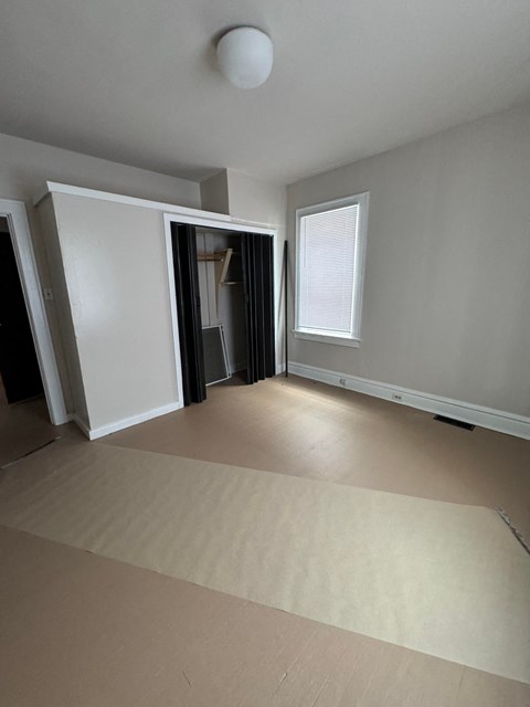 a living room with a carpet and a door to a bedroom