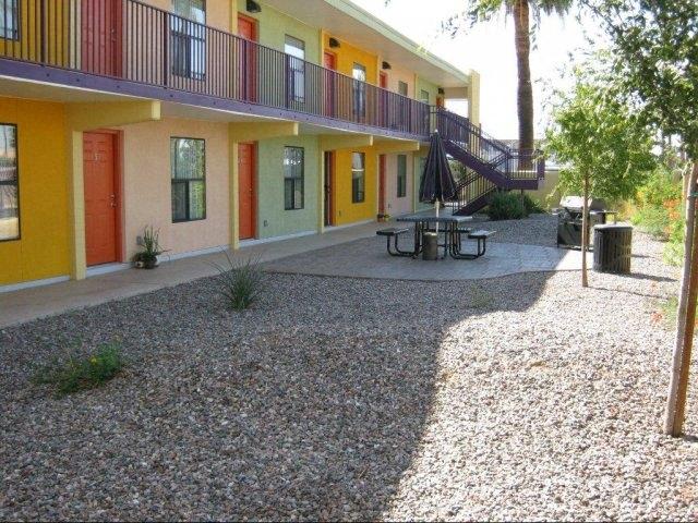 the outside of a building with a patio and tables