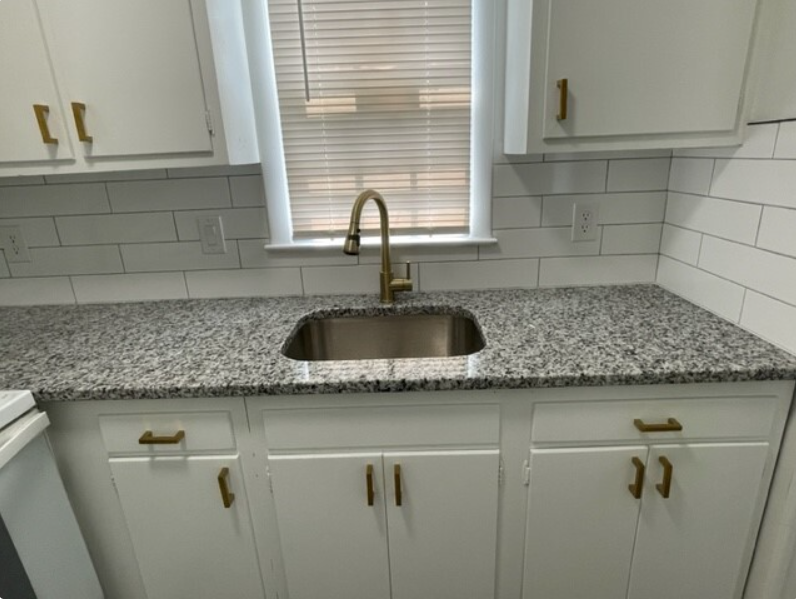 a kitchen with granite counter top and a sink