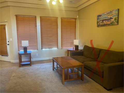 A living room with a brown couch, a coffee table, and a lamp.