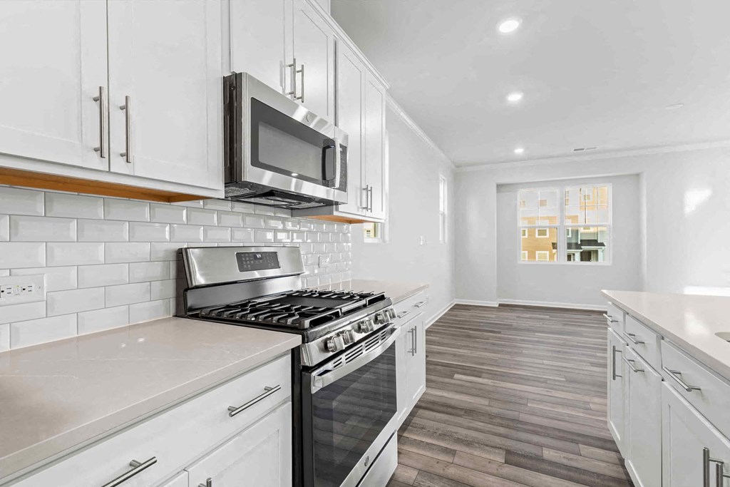 a kitchen with white cabinets and a stove and a microwave