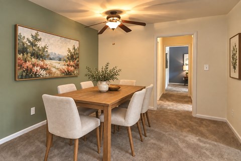 A dining room with a wooden table and chairs.