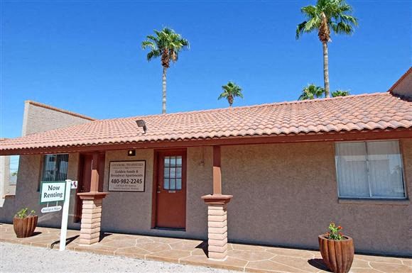 a small building with two palm trees in front of it