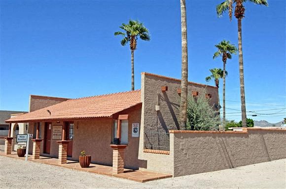 a small building with palm trees in front of it