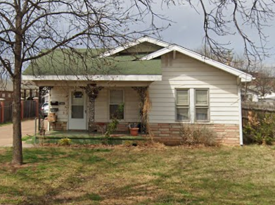 a small white house with a green roof