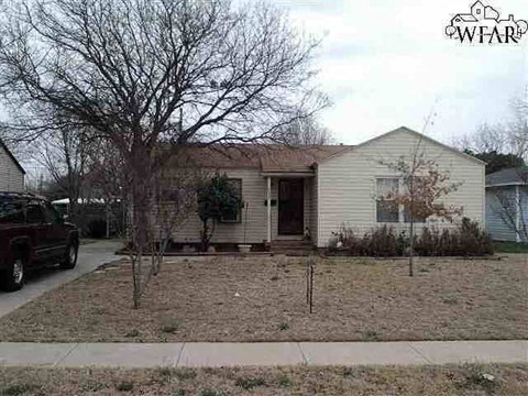 a white house with a yard and a tree
