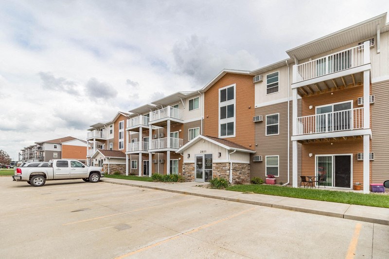 an empty parking lot in front of an apartment building