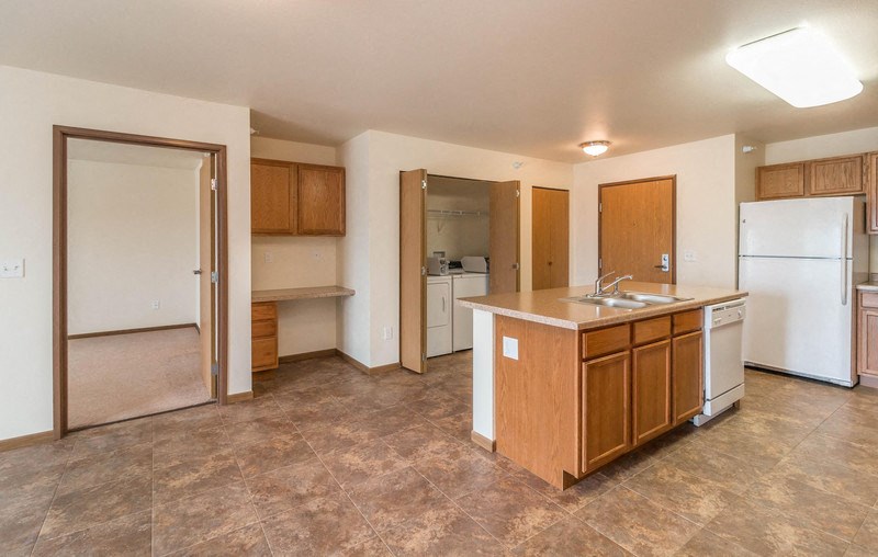 an empty kitchen with a sink and a refrigerator