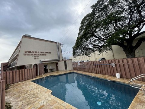 the swimming pool is next to a fence and a building