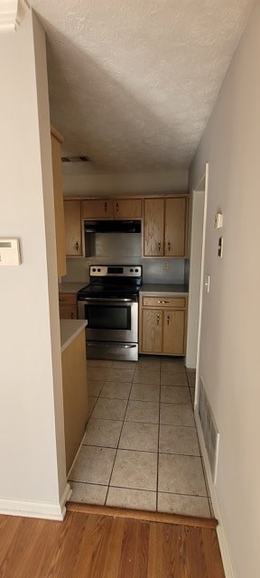 A kitchen with wooden cabinets and a tile floor.