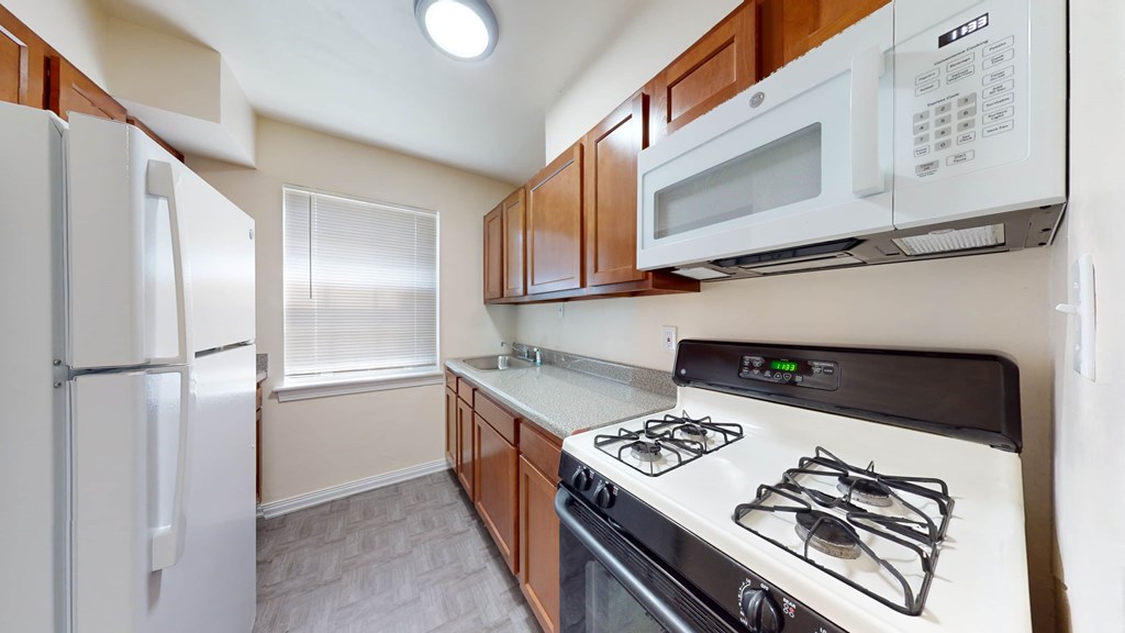 A kitchen with a white refrigerator, a white microwave, and a white stove.