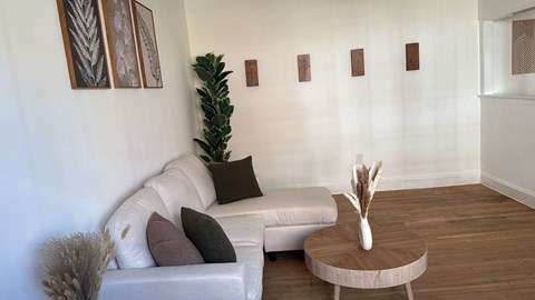 A living room with a white couch and a wooden coffee table.