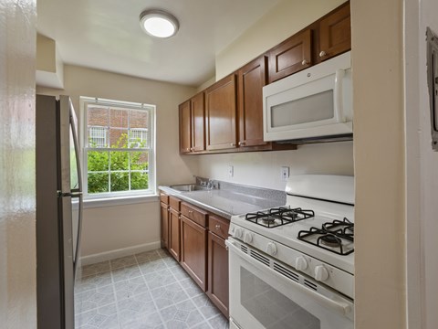 A kitchen with a white stove and brown cabinets.