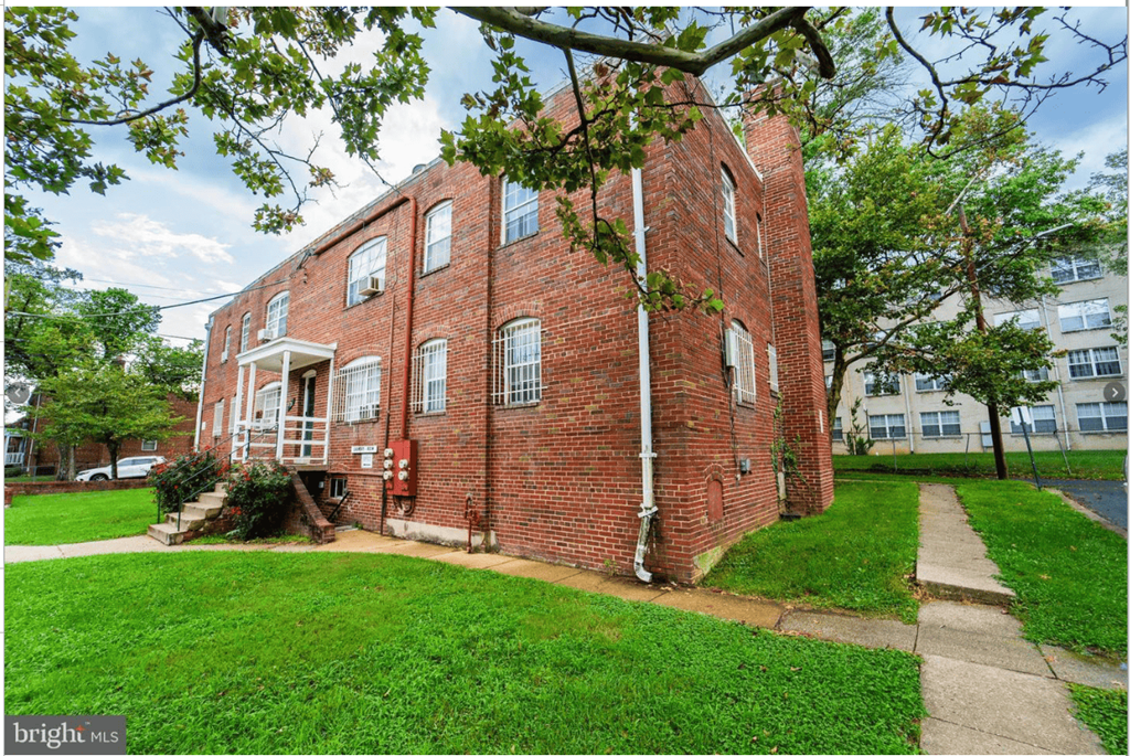 A red brick building with a white door and windows.