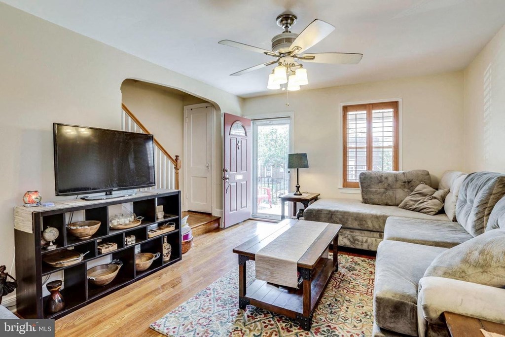 A living room with a television, couch, and a rug.