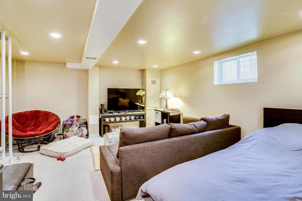 A living room with a couch, chair, and television.