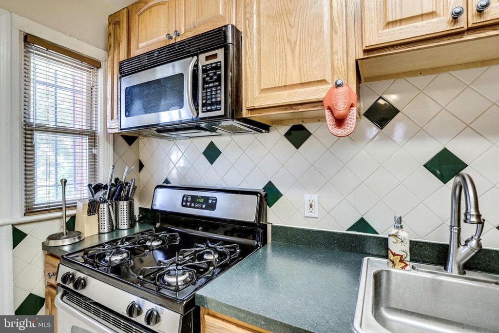 A kitchen with a stove, microwave, and oven.