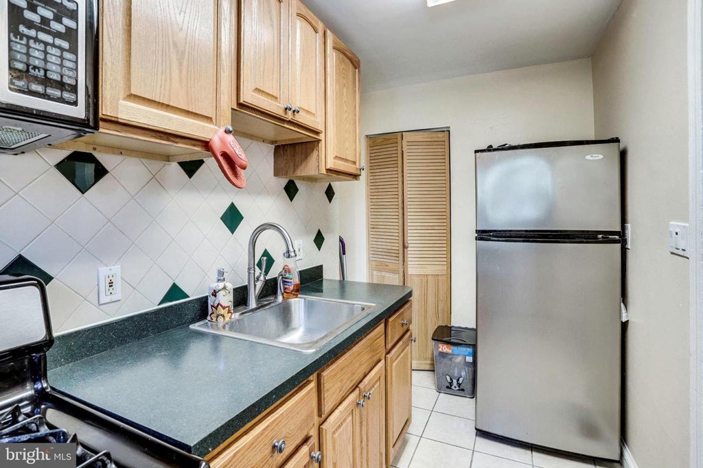 A kitchen with a black fridge and a black stove.