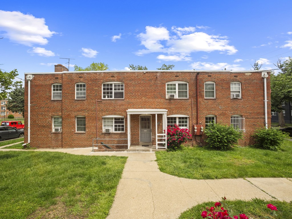 A red brick building with a white door and windows.