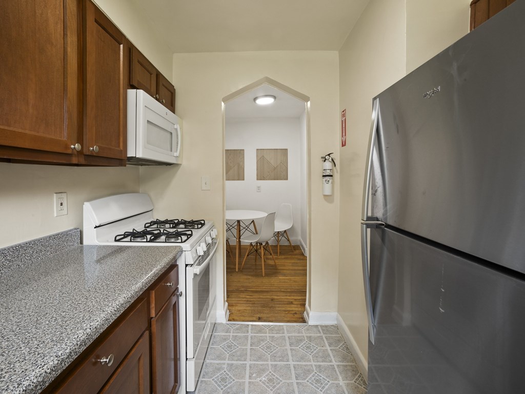 A kitchen with a stove, refrigerator, and cabinets.